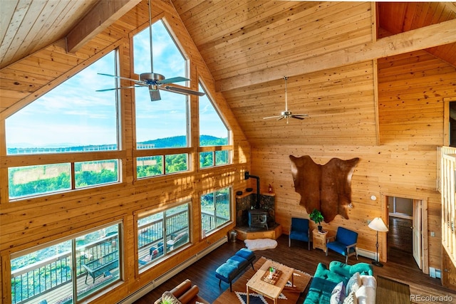 70 Sheep Creek Trl, Fairplay, CO 80440 - living area with a ceiling fan, high vaulted ceiling, a wood stove, wooden walls, and a wooden ceiling with exposed beams