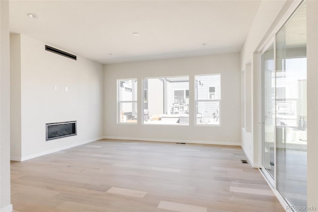 11324 Alla Breve Cir, Lone Tree, CO 80134 - unfurnished living room with light wood finished floors and a glass covered fireplace