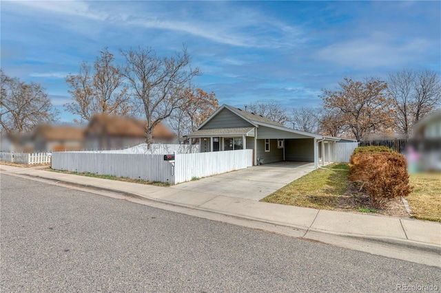 6660 Locust St, Commerce City, CO 80022 - view of front of home featuring an attached carport, concrete driveway, and a fenced front yard