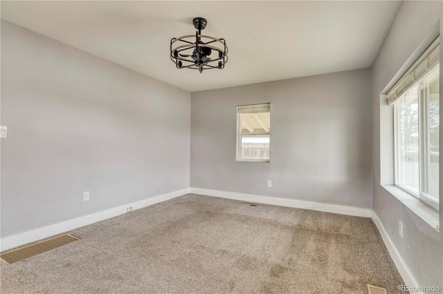 6660 Locust St, Commerce City, CO 80022 - carpeted empty room featuring a chandelier, visible vents, plenty of natural light, and baseboards