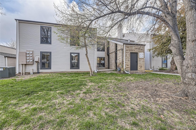 3550 S Harlan St Unit 311, Denver, CO 80235 - rear view of property featuring central AC unit, a yard, and brick siding