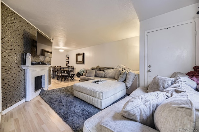 3550 S Harlan St Unit 311, Denver, CO 80235 - living area with light wood-style floors and a brick fireplace