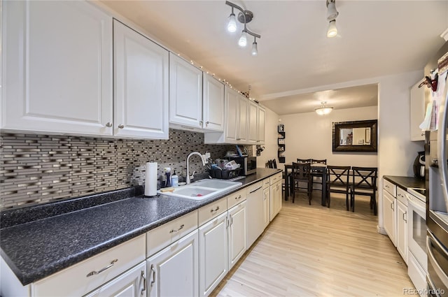 3550 S Harlan St Unit 311, Denver, CO 80235 - kitchen featuring a sink, dishwasher, dark countertops, and decorative backsplash
