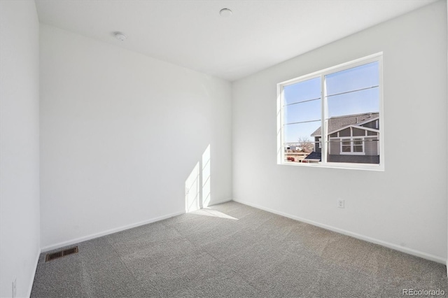 unfurnished room featuring carpet, visible vents, and baseboards