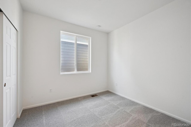 unfurnished bedroom with a closet, carpet flooring, baseboards, and visible vents