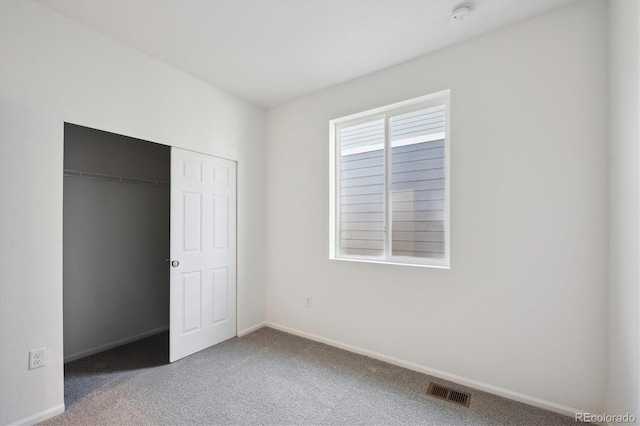 unfurnished bedroom featuring a closet, visible vents, baseboards, and carpet floors