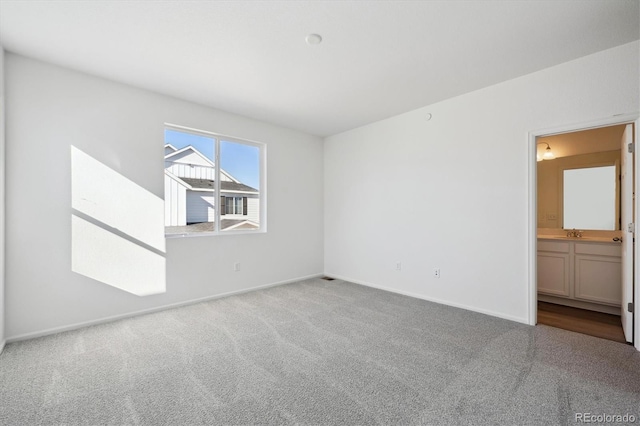 carpeted spare room featuring baseboards