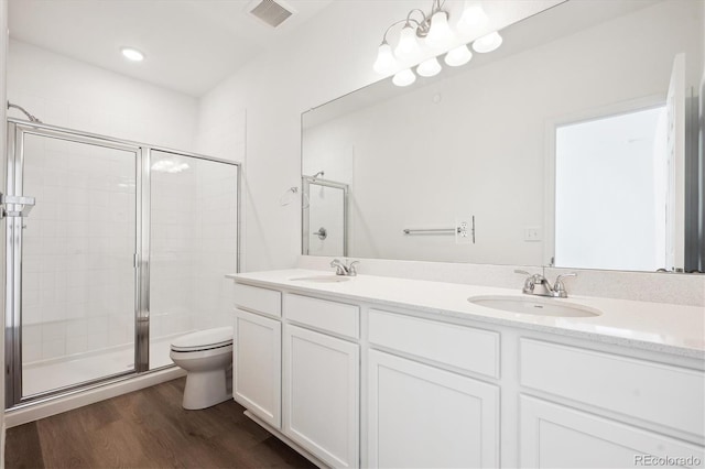 bathroom featuring a sink, visible vents, a stall shower, and wood finished floors