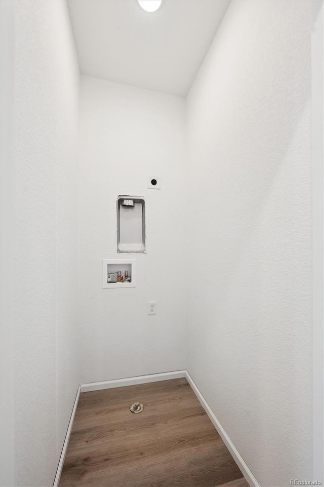 laundry room featuring electric dryer hookup, washer hookup, wood finished floors, baseboards, and laundry area