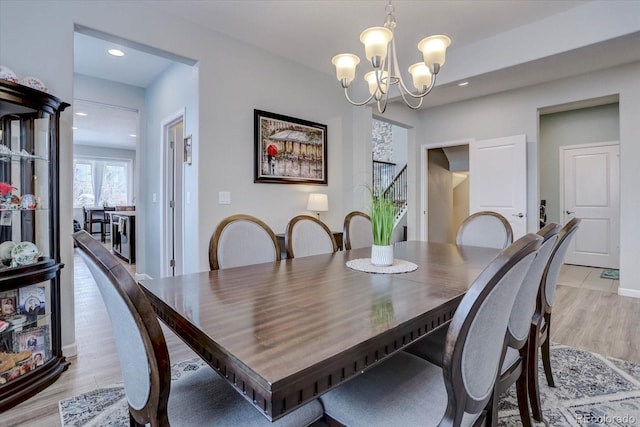 dining space featuring a notable chandelier and light hardwood / wood-style floors