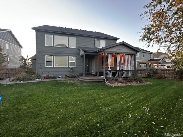 rear view of property featuring a lawn