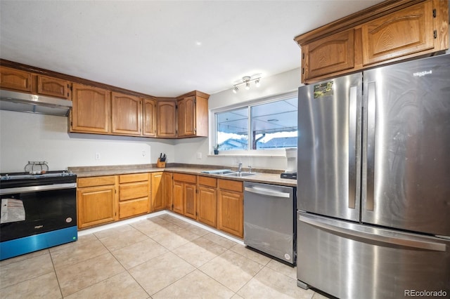 kitchen with stainless steel appliances, sink, and light tile patterned floors