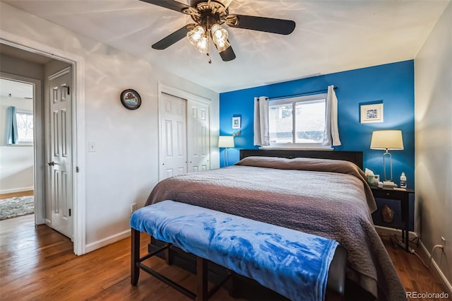 bedroom with hardwood / wood-style floors, a closet, ceiling fan, and multiple windows