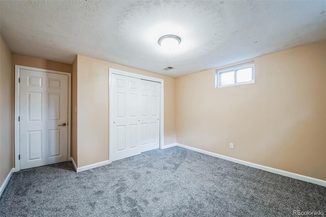 unfurnished bedroom with a textured ceiling and carpet