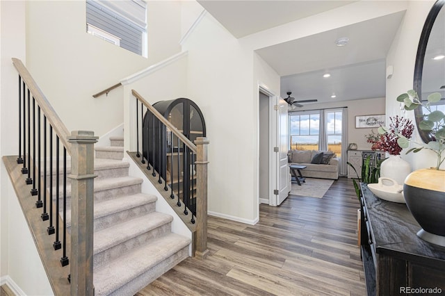 stairs with recessed lighting, ceiling fan, baseboards, and wood finished floors