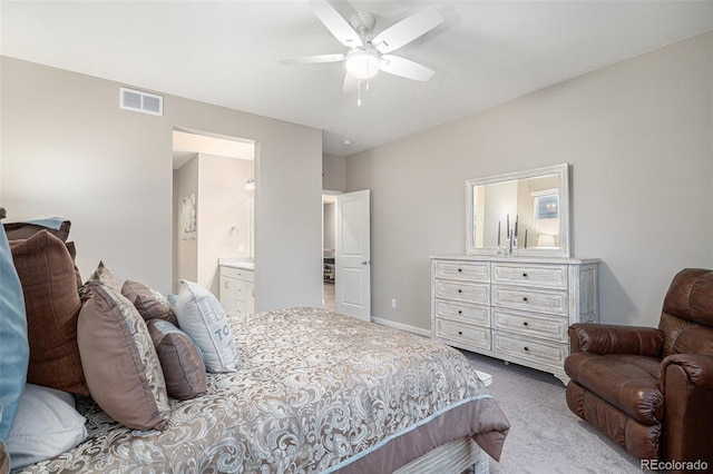 carpeted bedroom with ensuite bath and ceiling fan