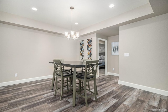 dining room with dark wood-type flooring and a notable chandelier