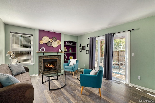 living room featuring a stone fireplace and hardwood / wood-style flooring