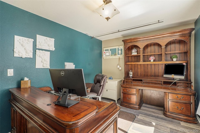 office space featuring built in desk and light hardwood / wood-style floors