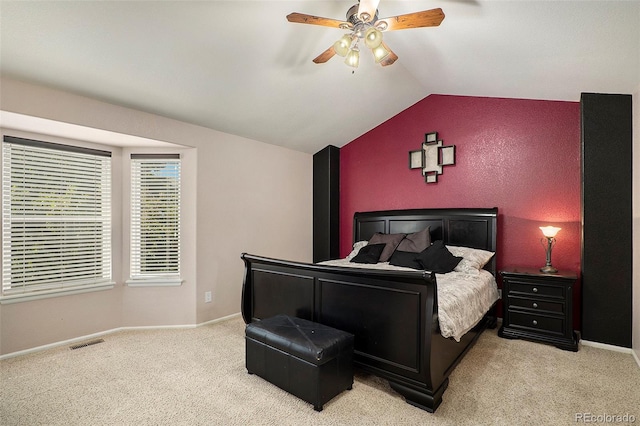 carpeted bedroom with ceiling fan and vaulted ceiling