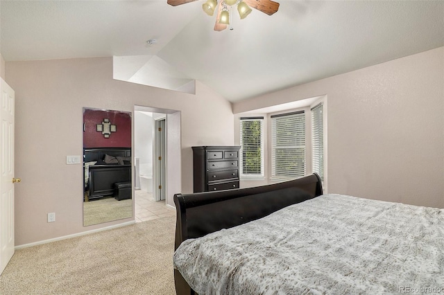 carpeted bedroom with connected bathroom, lofted ceiling, and ceiling fan