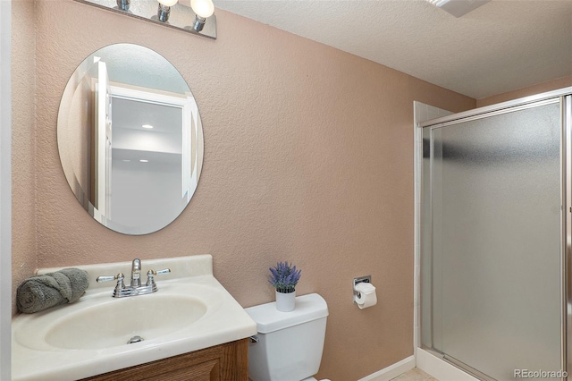 bathroom with vanity, a textured ceiling, an enclosed shower, and toilet