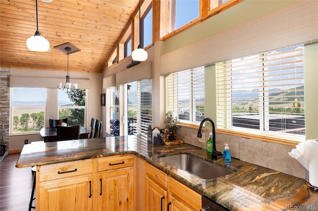 1301 Sheep Ridge Rd, Fairplay, CO 80440 - kitchen with a chandelier, a kitchen bar, wood finished floors, dark stone countertops, and vaulted ceiling