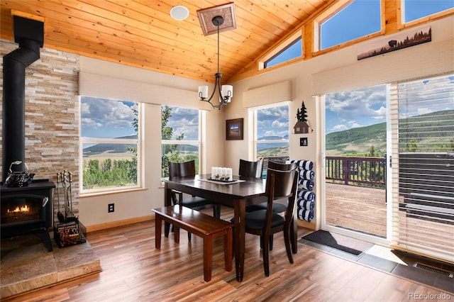 1301 Sheep Ridge Rd, Fairplay, CO 80440 - dining space featuring a wood stove, wood ceiling, wood finished floors, a chandelier, and high vaulted ceiling