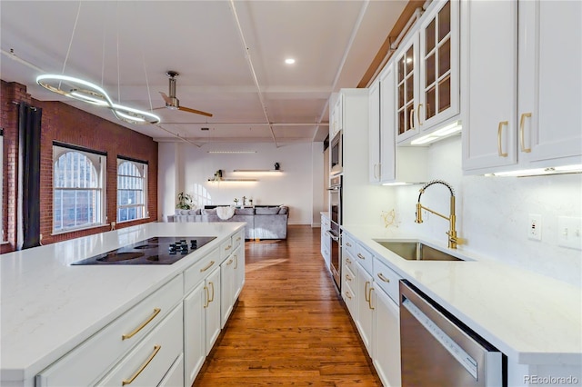 1555 California St Unit 605, Denver, CO 80202 - kitchen featuring appliances with stainless steel finishes, a sink, ceiling fan, wood finished floors, and white cabinets