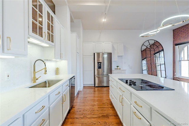 1555 California St Unit 605, Denver, CO 80202 - kitchen with stainless steel appliances, a sink, light countertops, white cabinets, and light wood-type flooring