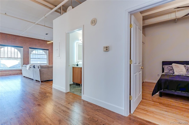 1555 California St Unit 605, Denver, CO 80202 - bedroom with wood finished floors, brick wall, and baseboards