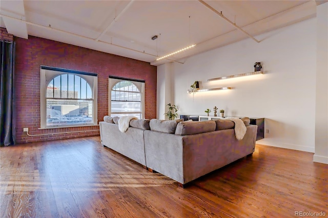 1555 California St Unit 605, Denver, CO 80202 - living area with wood finished floors, brick wall, a towering ceiling, and baseboards