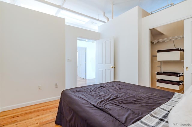 1555 California St Unit 605, Denver, CO 80202 - bedroom with wood finished floors, baseboards, a spacious closet, and a closet