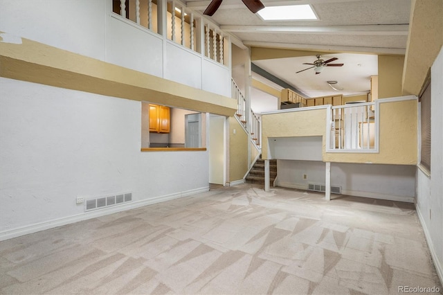 7210 Otis Ct, Arvada, CO 80003 - unfurnished living room featuring a ceiling fan, carpet floors, beam ceiling, stairs, and high vaulted ceiling