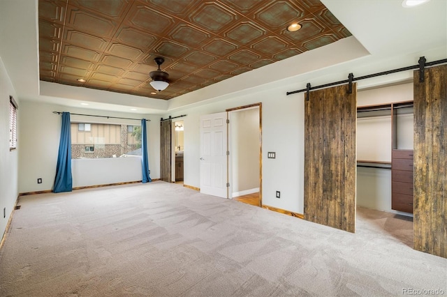 7210 Otis Ct, Arvada, CO 80003 - unfurnished bedroom with a barn door, a tray ceiling, an ornate ceiling, carpet, and recessed lighting