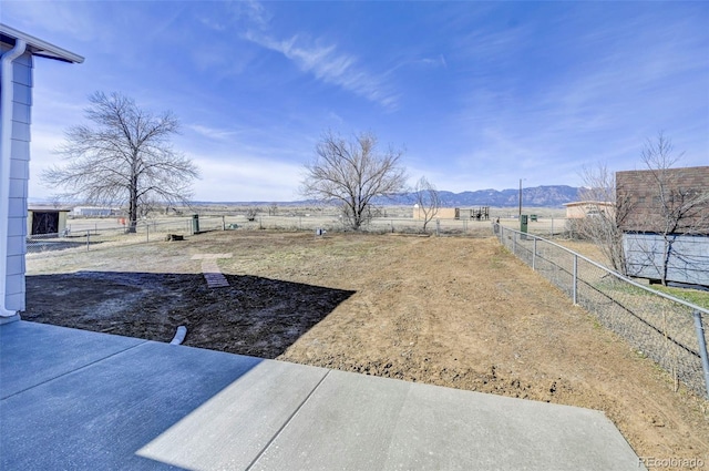 view of yard featuring a mountain view and fence