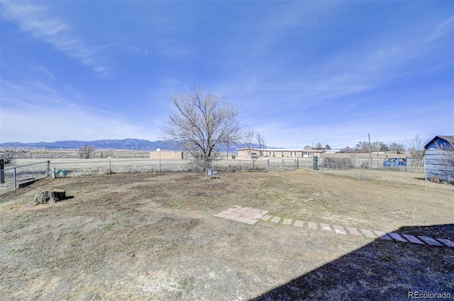 view of yard featuring fence and a mountain view