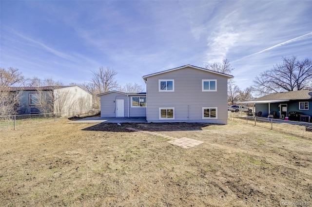 rear view of house featuring an outdoor structure and a fenced backyard