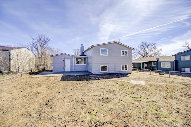 back of house featuring a fenced backyard, a chimney, and a patio area