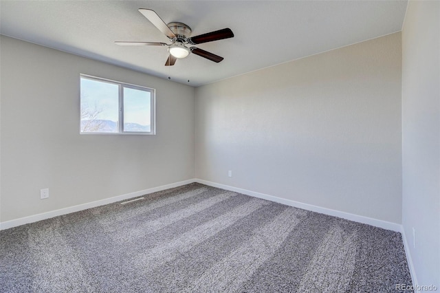 carpeted empty room featuring visible vents, baseboards, and a ceiling fan