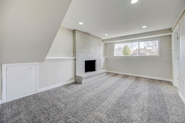 unfurnished living room featuring recessed lighting, a brick fireplace, baseboards, and carpet floors