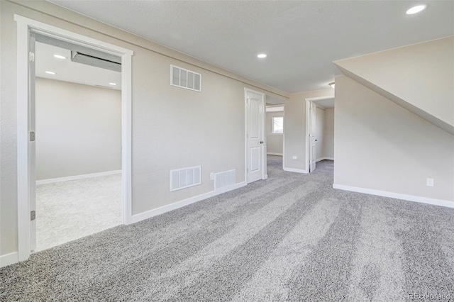 carpeted spare room with recessed lighting, visible vents, and baseboards