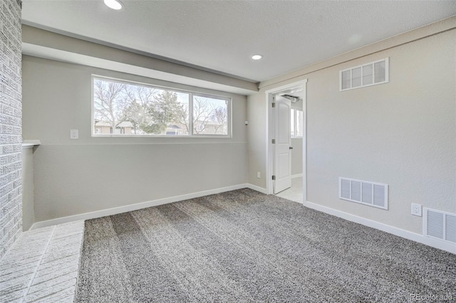 spare room featuring visible vents, baseboards, and carpet