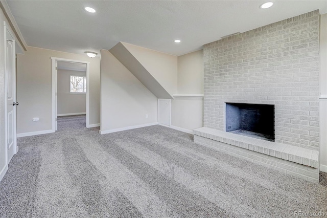 unfurnished living room with carpet flooring, recessed lighting, a fireplace, and baseboards