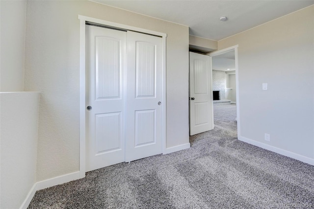 unfurnished bedroom featuring a closet, baseboards, and carpet floors