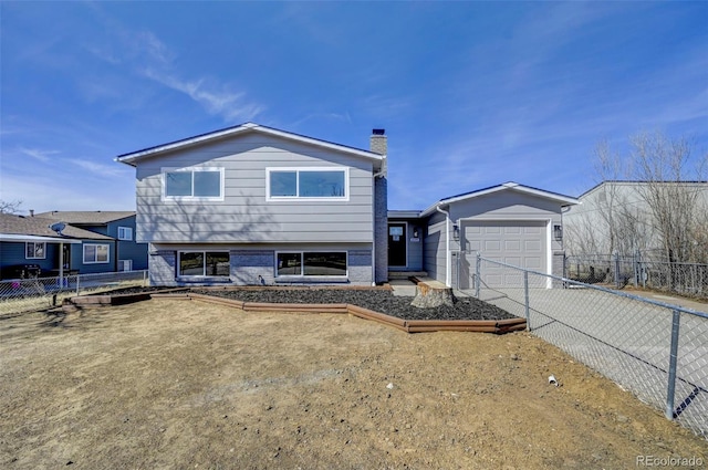 tri-level home with concrete driveway, a chimney, a garage, and fence