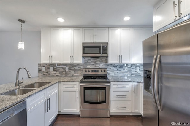 kitchen featuring sink, decorative light fixtures, stainless steel appliances, and white cabinets