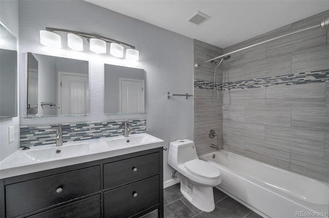 full bathroom with vanity, decorative backsplash, tile patterned floors, toilet, and tiled shower / bath