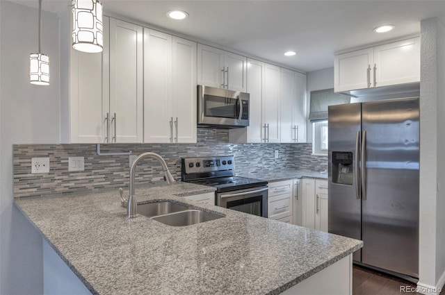 kitchen with white cabinetry, appliances with stainless steel finishes, sink, and kitchen peninsula