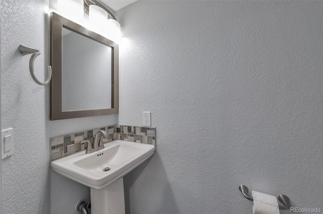 bathroom with sink and decorative backsplash